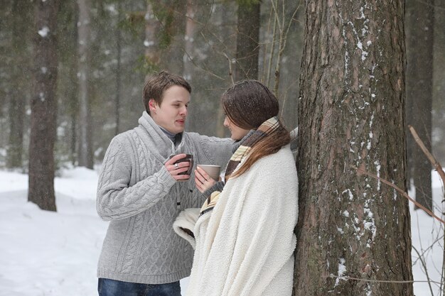 Um casal de namorados em um encontro à tarde de inverno sob uma nevasca