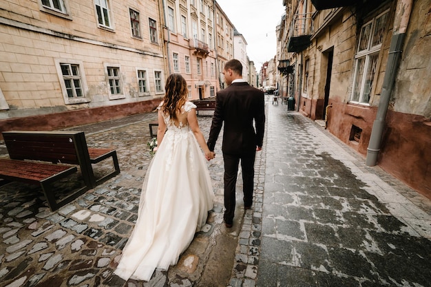 Um casal de noivos está voltando pelas ruas da cidade de lviv.