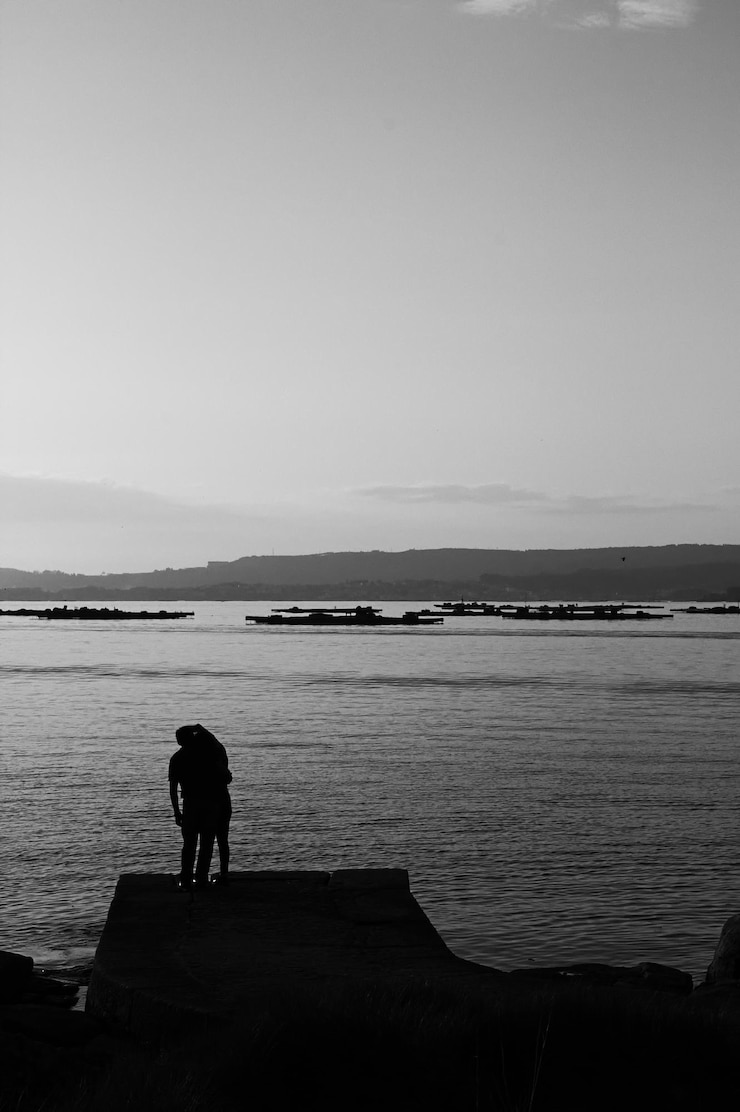 Foto um casal de pé na praia contra o céu