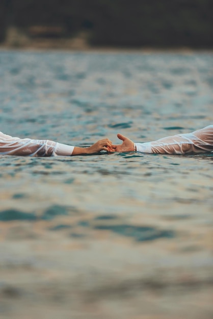 Um casal de roupas de mãos dadas no mar. foto de alta qualidade