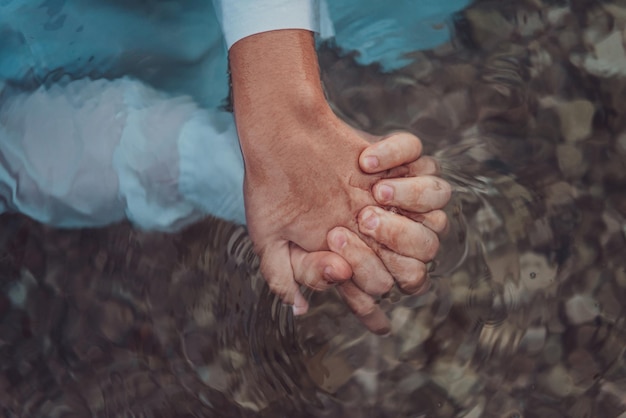 Um casal de roupas de mãos dadas no mar. foto de alta qualidade