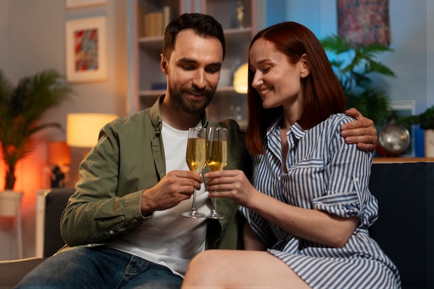 Foto um casal de tiros médios a relaxar em casa.