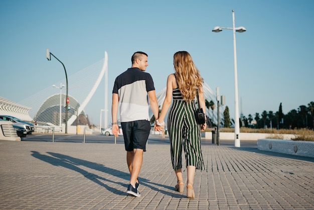 Um casal de turistas no espaço urbano moderno em um encontro à noite na Espanha