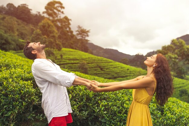 Foto um casal de viajantes apaixonados em frente a plantações de chá nas montanhas