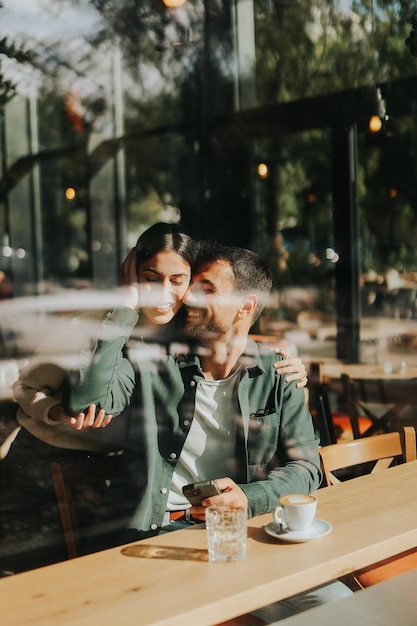 Um casal desfrutando de uma tarde quente juntos em um café aconchegante compartilhando sorrisos e risadas ao longo do café