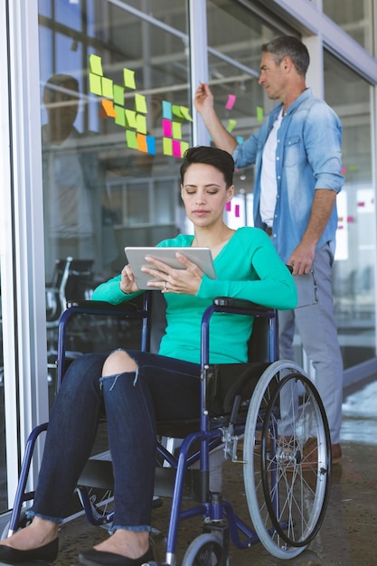 Um casal diverso está trabalhando juntos mulher usando tablet