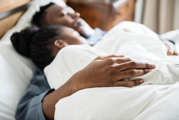 Um casal dormindo na cama