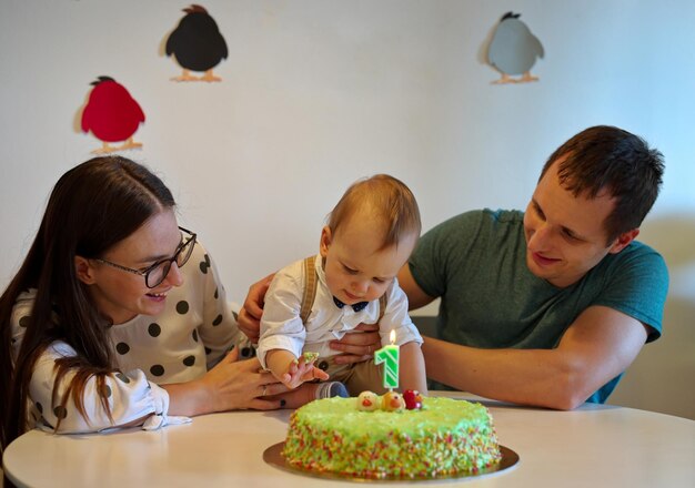 Foto um casal e o seu lindo menino a celebrar o seu primeiro aniversário.