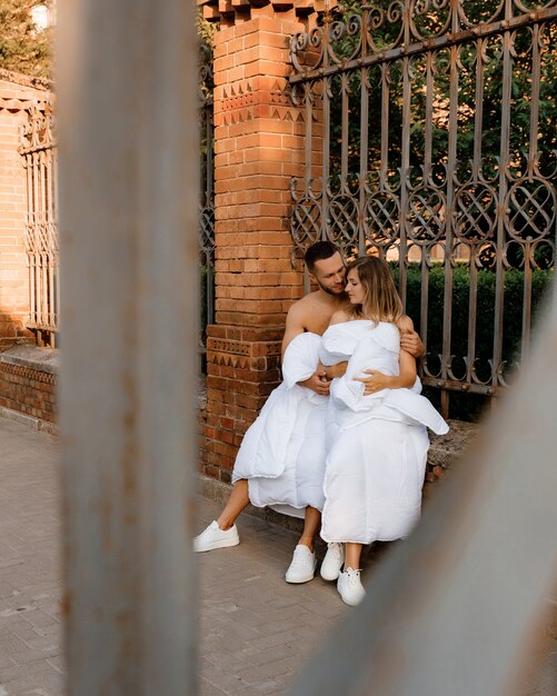 Foto um casal em cobertores andando pela cidade