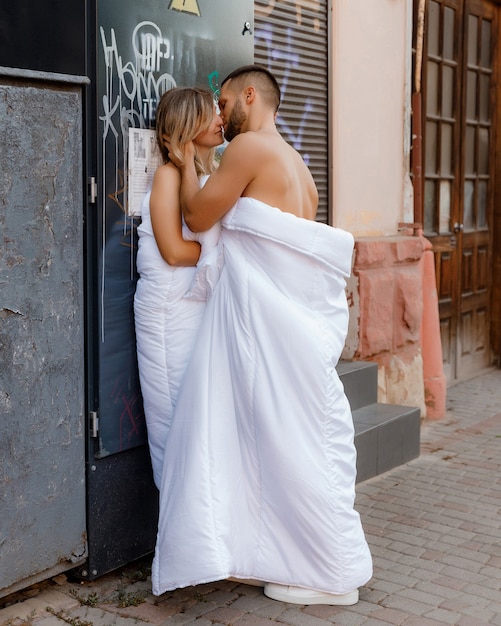 Foto um casal em cobertores andando pela cidade