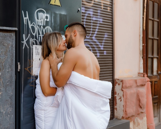 Foto um casal em cobertores andando pela cidade