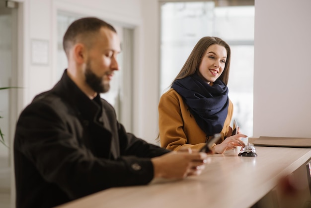 Um casal em pé na recepção e esperando o serviço