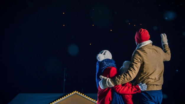 Foto um casal em uma cena de natal com luzes ao fundo