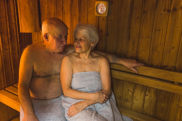 Um casal em uma sauna com um relógio na parede