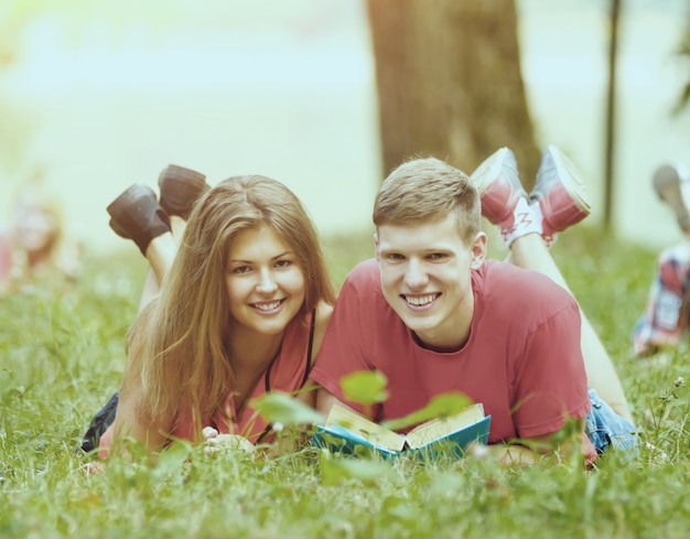 Um casal estudante com livros didáticos no parque