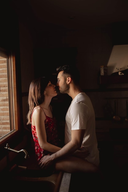 Um casal feliz a beijar-se na cozinha.