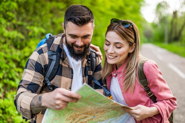 Um casal feliz a caminhar na natureza e a olhar para o mapa um casal a desfrutar das férias