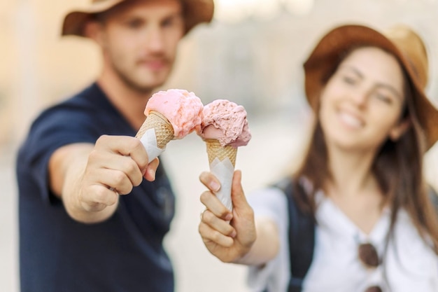 Foto um casal feliz a comer gelado em roma, itália. um belo gelado brilhante nas mãos.