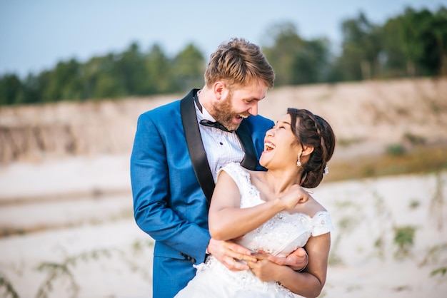 Um casal feliz abraçando-se enquanto está ao ar livre