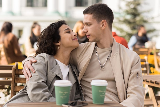 Um casal feliz ao ar livre perto de um café