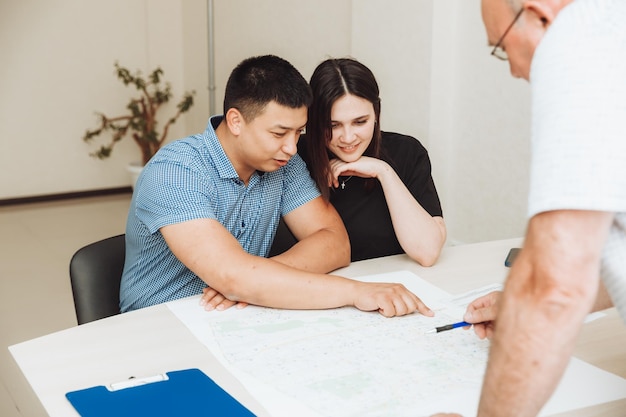 Um casal feliz assina um contrato juntos no escritório um homem e uma mulher compram um apartamento e assinam um contrato