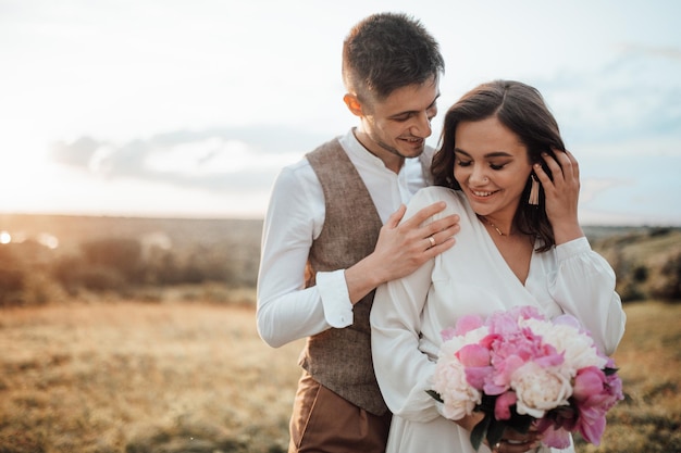 Foto um casal feliz com flores cor-de-rosa contra um fundo desfocado