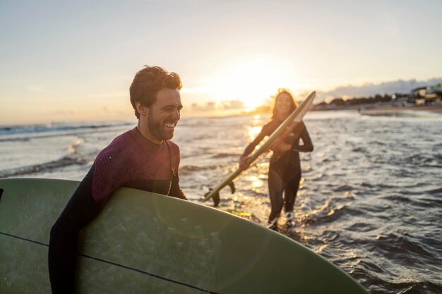 Um casal feliz com pranchas de surf se preparando para a ação