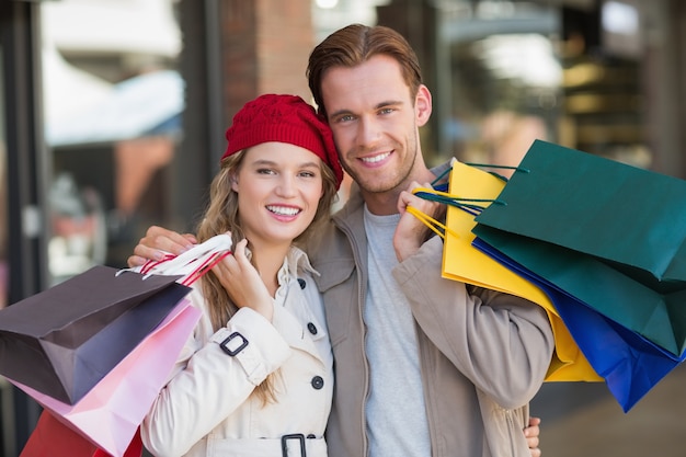 Um casal feliz com sacolas de compras