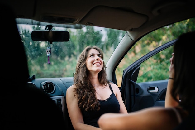 Um casal feliz de lésbicas sentado no carro.