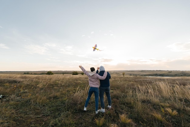 Um casal feliz empina pipa e passa tempo juntos ao ar livre em uma reserva natural Relacionamentos felizes e férias em família Liberdade e espaço