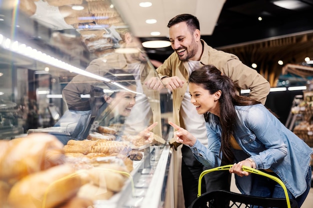 Um casal feliz escolhendo supermercado de pastelaria