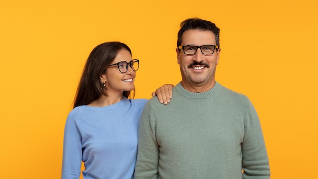 Foto um casal feliz fica ombro a ombro com a mulher de óculos