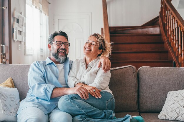 Foto um casal feliz sentado no sofá em casa.