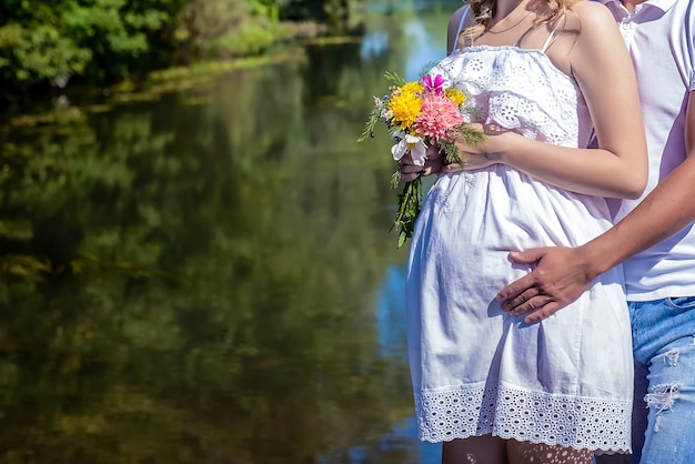 Um casal grávida segura a barriga