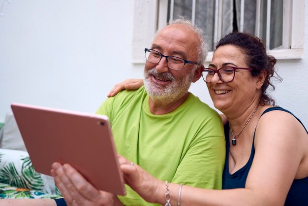 Foto um casal idoso fazendo uma chamada de vídeo com um conceito de tablet idosos