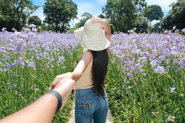 Um casal jovem viajante asiático de mãos dadas entre naga flor campo de crista na natureza em férias e ter um tempo feliz