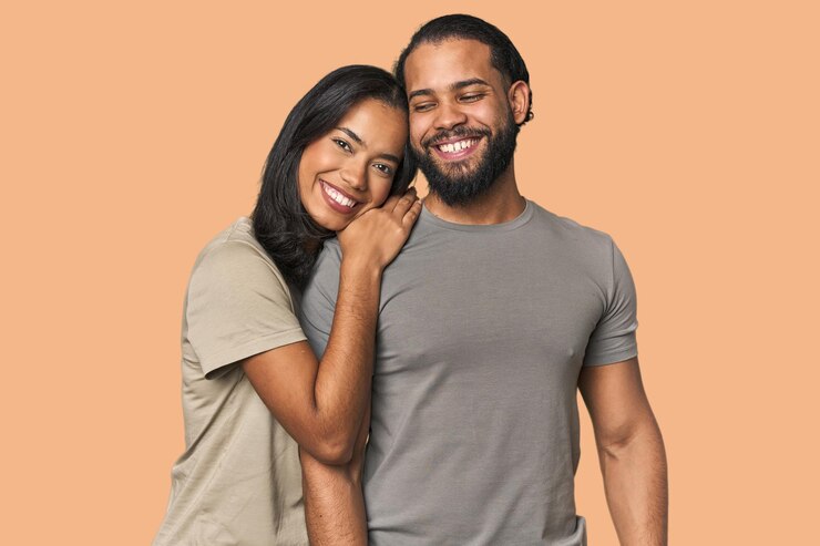 Foto um casal latino apaixonado abraçando-se calorosamente no estúdio.