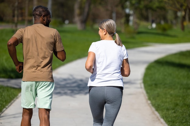 Foto um casal maduro a correr juntos no parque.