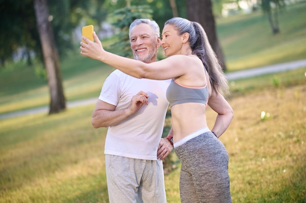 Um casal maduro e feliz fazendo selfie e parecendo satisfeito