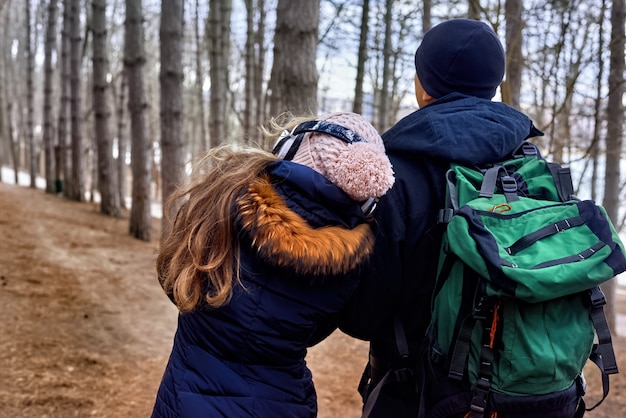 Foto um casal na floresta de fim de inverno com mochila