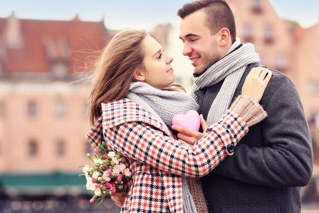 um casal no Dia dos Namorados na cidade com flores e coração