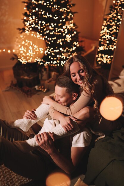 Foto um casal romântico apaixonado celebra as férias de natal e ano novo em uma casa aconchegante à noite