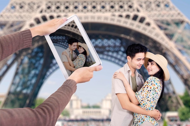 Um casal romântico debaixo da Torre Eiffel, em Paris.