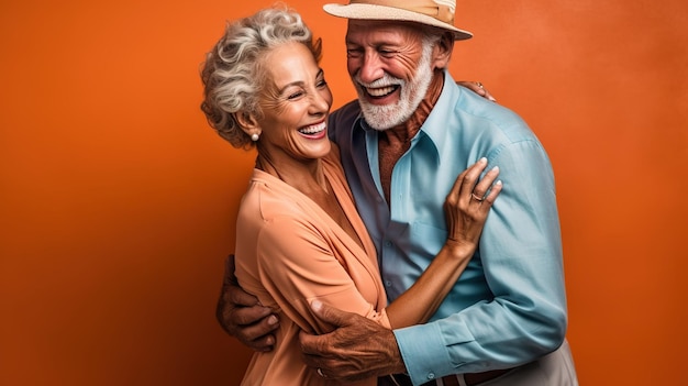 Foto um casal se abraça diante de um fundo laranja.