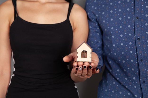 Um casal segurando uma casa