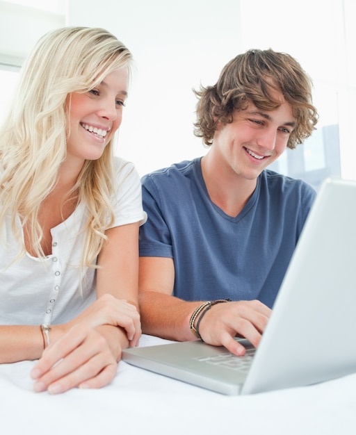 Um casal sorridente se sente ao navegar na internet