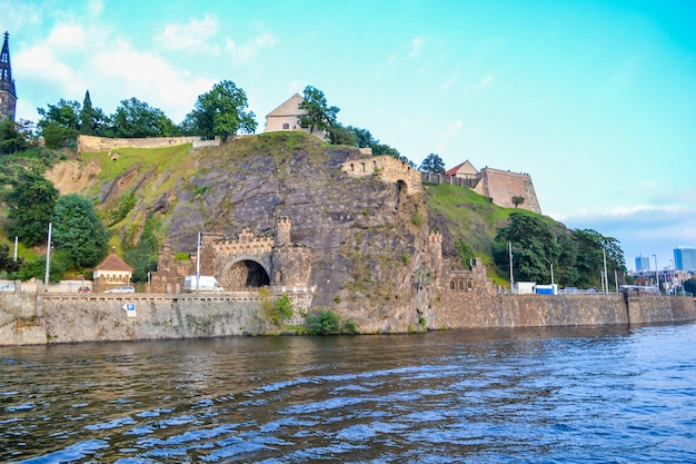 um castelo está no lado de uma colina República Checa Praga Monumentos edifícios rio Vltava