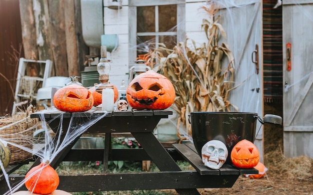 Um celeiro decorado para o halloween com abóboras esculpidas e teias de aranha