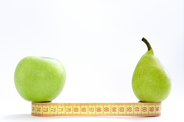 Um centímetro, uma maçã e uma pêra verde ficar em um fundo branco