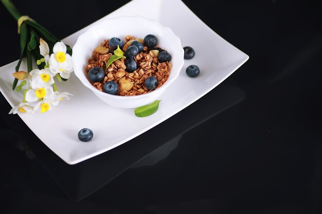 Um cereal matinal saudável com leite e frutas. Flocos de aveia e milho com chocolate e iogurte. O conceito de alimentação saudável e vegetariana.